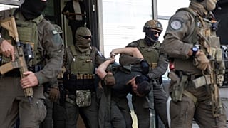 Policías kosovares sacan del tribunal en Prístina, la capital kosovar, a uno de los serbios implicados en el tiroteo