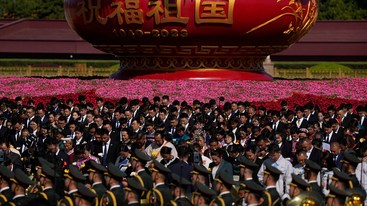 Participants bow to pay respects to the People's Heroes Monument during a ceremony to mark Martyr's Day at Tiananmen Square in Beijing, Saturday, Sept. 30, 2023.
