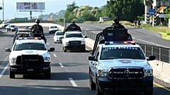 Members of the Civil Guard escort a truck carrying lemons (out of frame) in the Apatzingan-Nueva Italia highway section, Michoacan State, Mexico, on September 20, 2023. 
