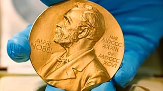 Un employé de la bibliothèque nationale montre une médaille d'or du prix Nobel.