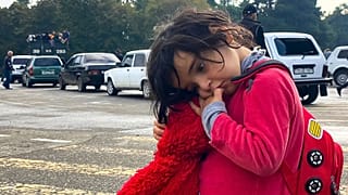 A child holds a toy as people hoping to leave Nagorno-Karabakh gather in the city of Stepanakert/Khankendi on September 26