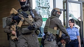 قوات من شرطة كوسوفو ترافق مسلحين صرب إلى خارج مبنى محكمة بعد إطلاق النار المتبادل في شمال كوسوفو قبل عدة أيام