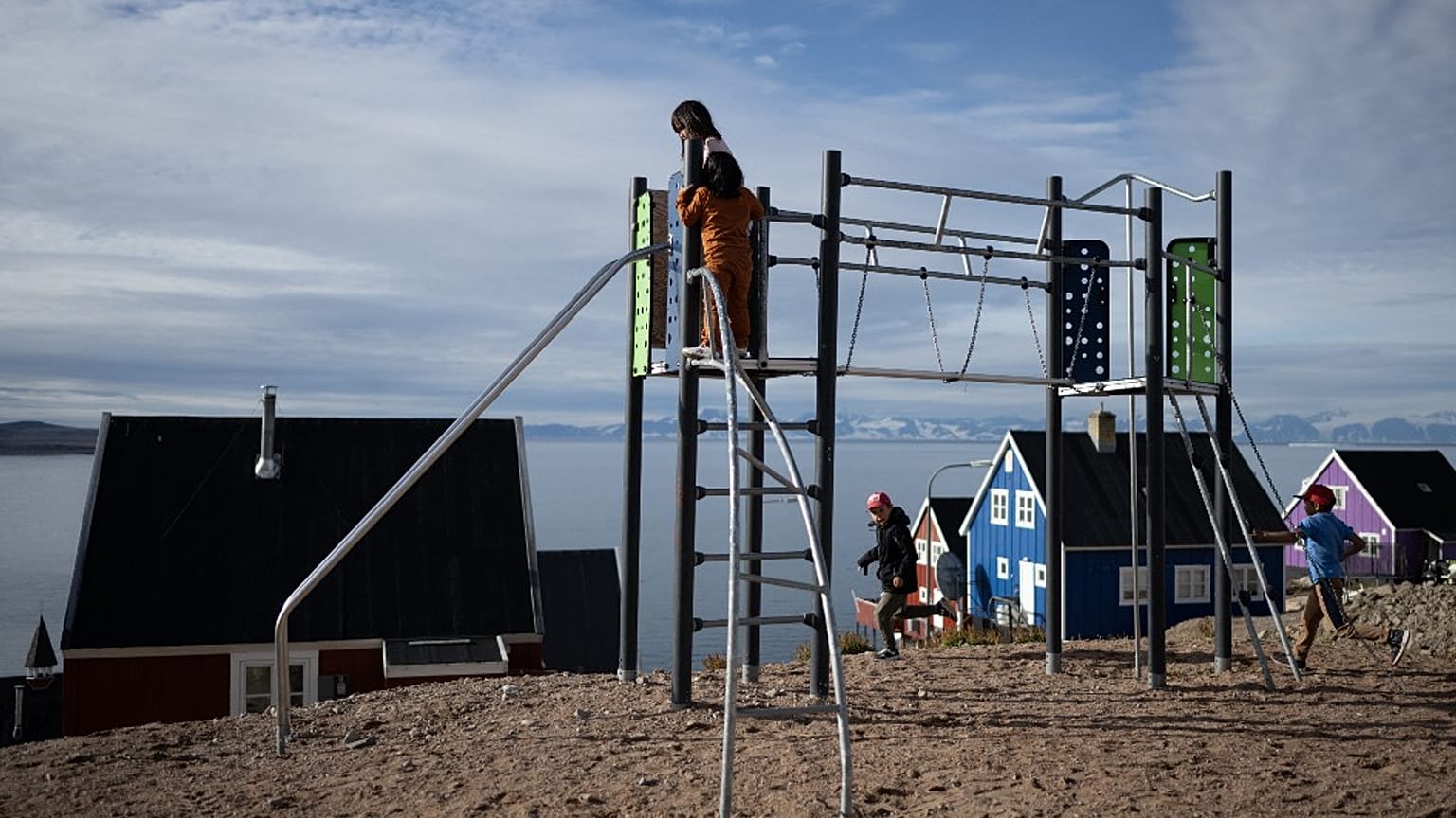 Des enfants jouent sur un terrain de jeu dans le village isolé d'Ittoqqortoormiit au Groenland oriental, dans le fjord de Scoresby Sound, au Groenland oriental, le 17 août 2023.