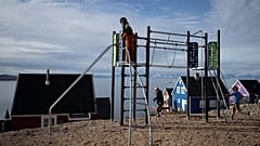 Kinder spielen auf einem Spielplatz in dem abgelegenen ostgrönländischen Dorf Ittoqqortoormiit im Scoresby Sound Fjord, Ostgrönland, am 17. August 2023.