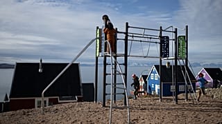 Unos niños juegan en un parque infantil en el remoto pueblo de Ittoqqortoormiit, en el fiordo de Scoresby Sound, Groenlandia oriental, el 17 de agosto de 2023.