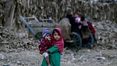 Pakistan'ın başkenti İslamabad'ın dışında yer alan bir mülteci kampında kardeşini kucaklayan bir Afgan göçmen kız çocuğu