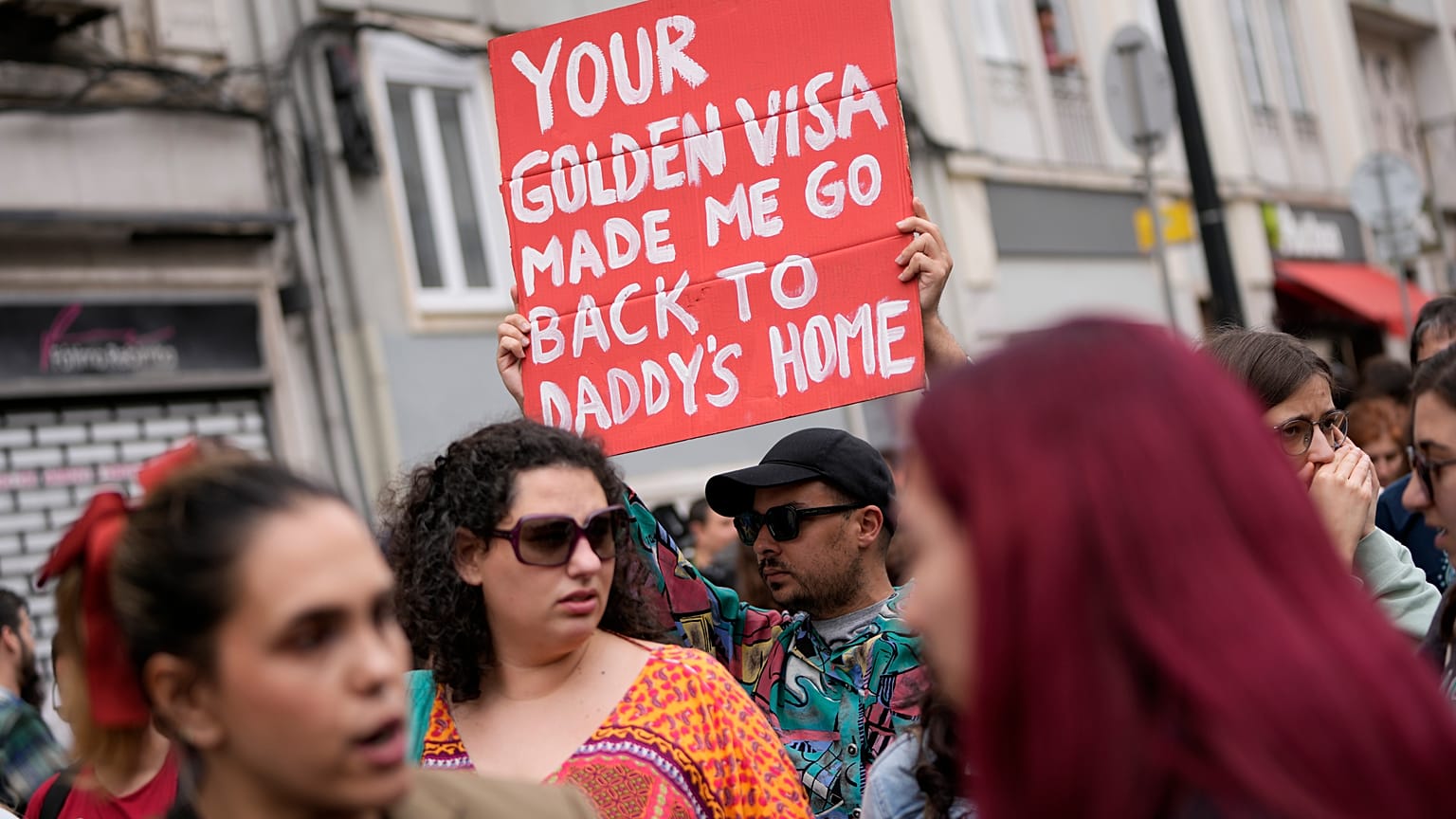 A protestor carries a poster during a demonstration to demand solutions for Portugal's housing crisis, in Lisbon, on April.