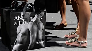 young women pause with their Abercrombie & Fitch shopping bags on the sidewalk along Fifth Avenue in New York. July 10, 2012