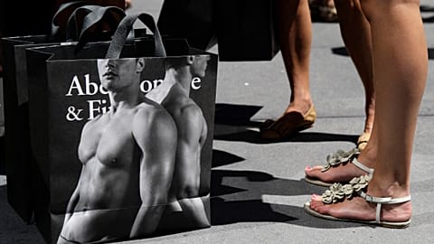 young women pause with their Abercrombie & Fitch shopping bags on the sidewalk along Fifth Avenue in New York. July 10, 2012