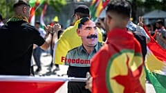 متظاهر كردي يرتدي علما بصورة عبد الله أوغلان