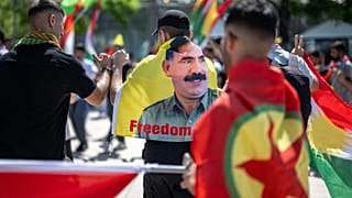متظاهر كردي يرتدي علما بصورة عبد الله أوغلان