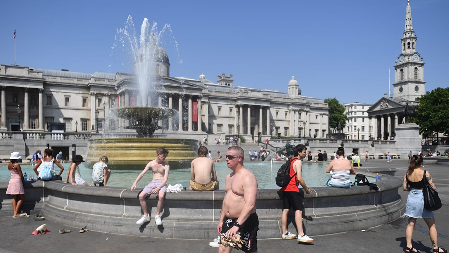 Emberek hűsölnek a londoni Trafalgar tér egyik szökőkútjában – képünk illusztráció