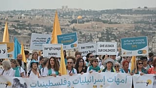 «Αρκετά» γράφει πλακάτ που κρατάει διαδηλώτρια στην πορεία ειρήνης