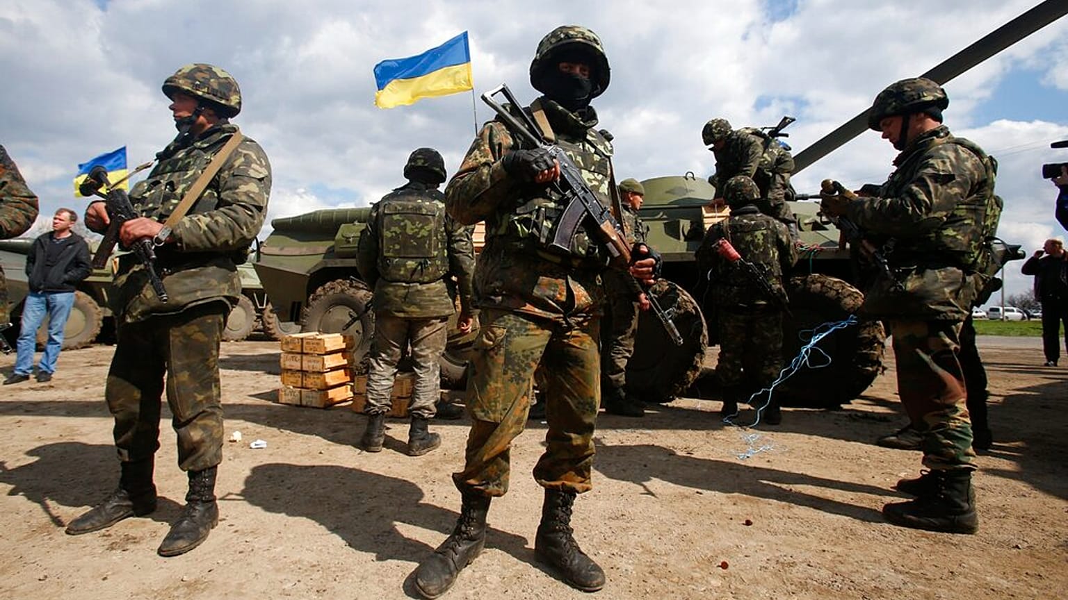 FILE - Ukrainian army troops receive ammunition, with a Ukrainian flag in the background, in a field on the outskirts of Izyum, Eastern Ukraine, Tuesday, April 15, 2014.