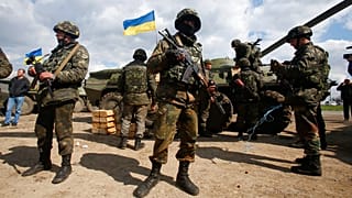 FILE - Ukrainian army troops receive ammunition, with a Ukrainian flag in the background, in a field on the outskirts of Izyum, Eastern Ukraine, Tuesday, April 15, 2014.