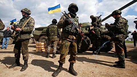 FILE - Ukrainian army troops receive ammunition, with a Ukrainian flag in the background, in a field on the outskirts of Izyum, Eastern Ukraine, Tuesday, April 15, 2014.