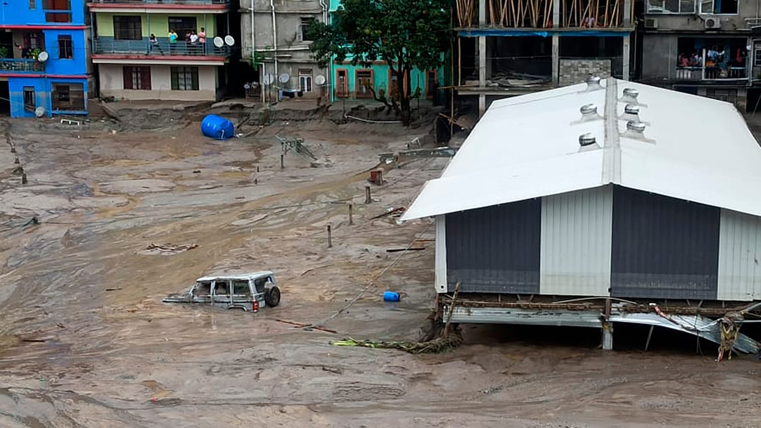 Um veículo é arrastado pelas cheias na cidade de Rangpo, no estado de Siquim, Índia