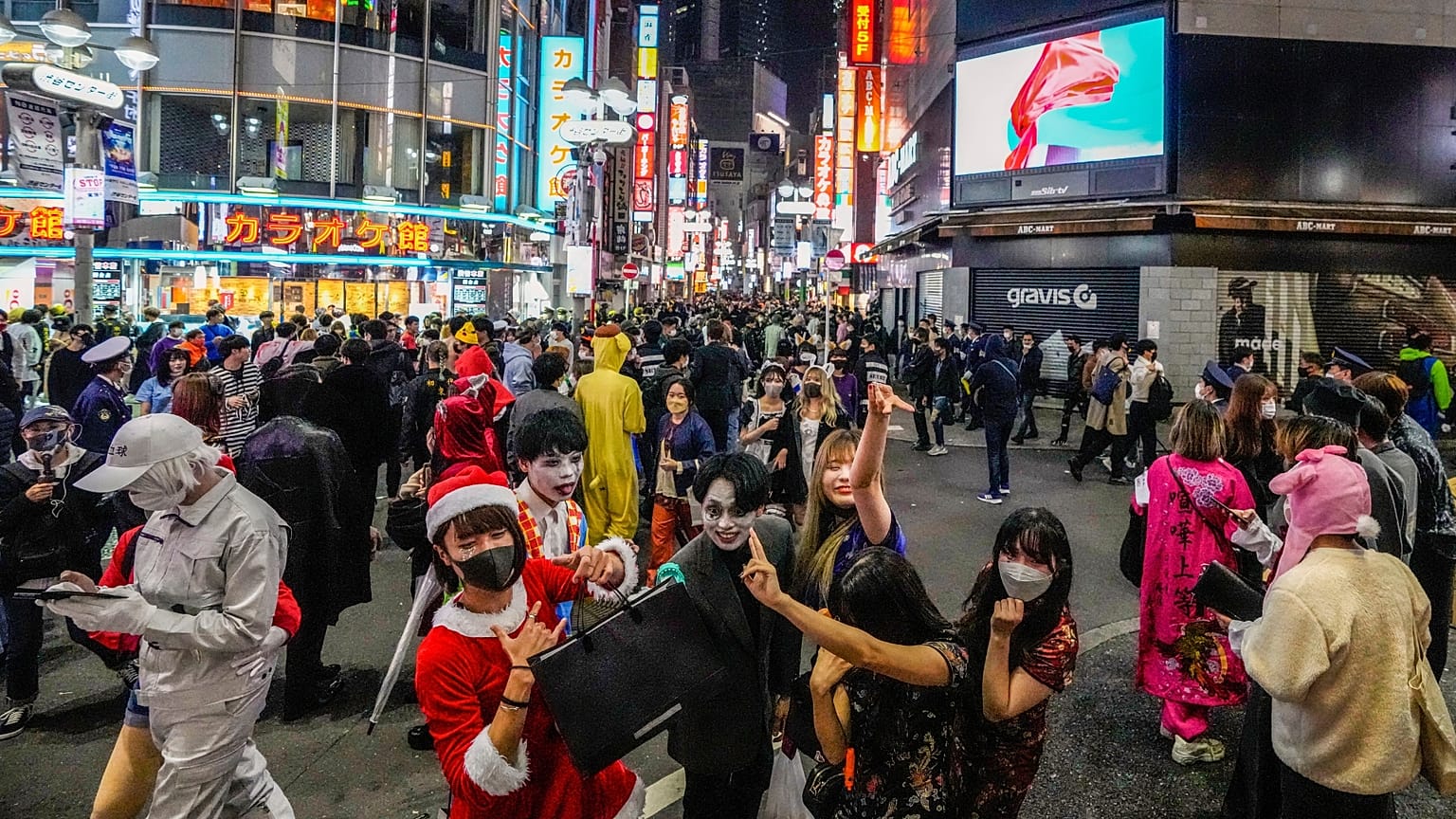Halloween goers in costumes pose for pictures as thousands gather in Shibuya district in 2021.