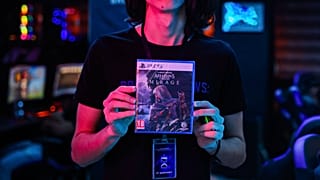 أحد الموظفين يعرض نسخة من لعبة الفيديو التي تم إصدارها حديثًا "Assassin's Creed Mirage"