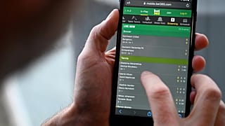A man browses online gambling website Bet365 on a smartphone.