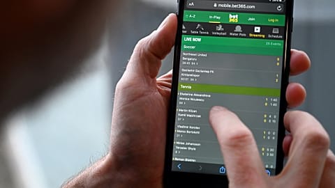A man browses online gambling website Bet365 on a smartphone.