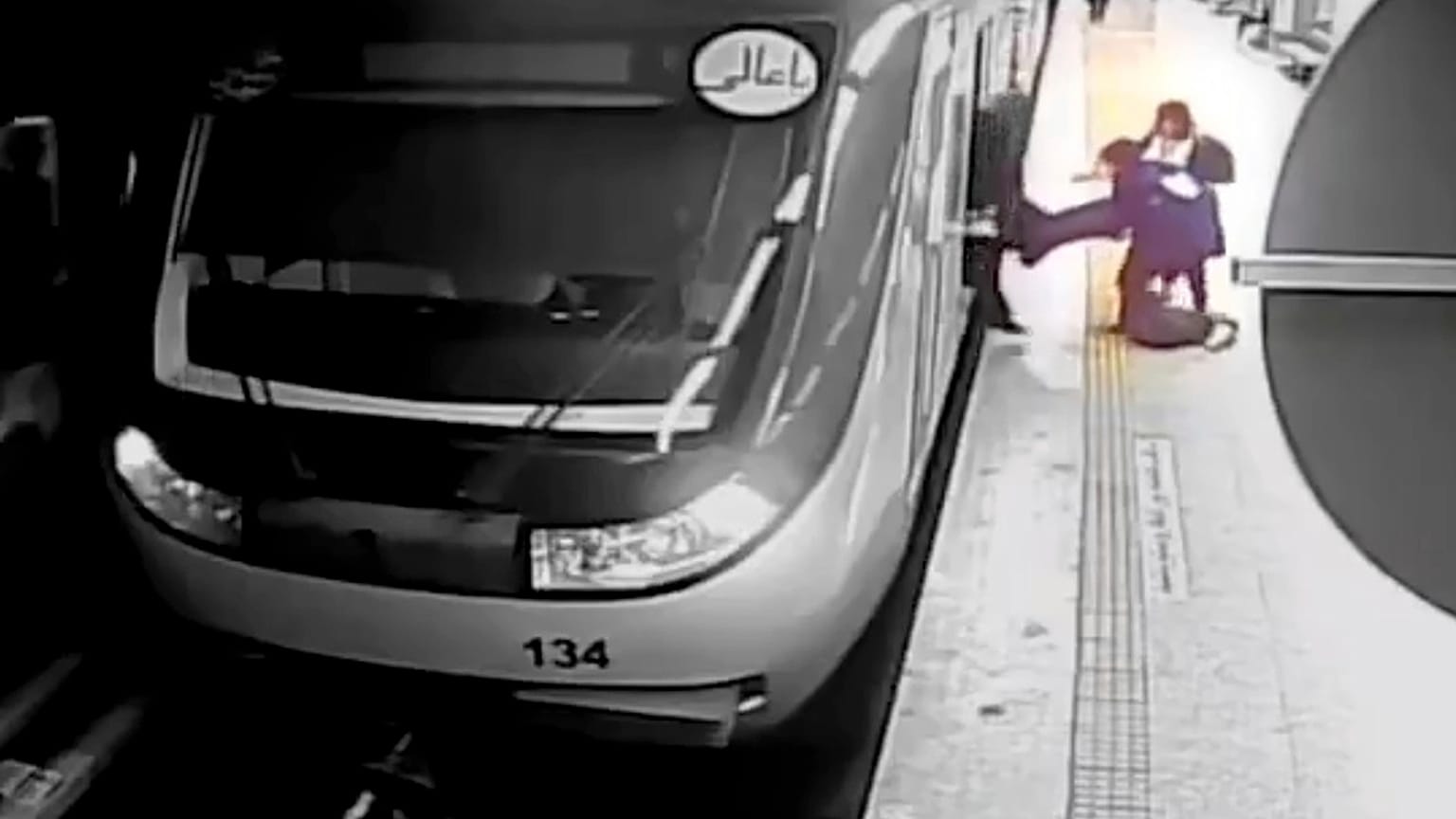Momento captado por las cámaras del metro de Teherán en el que las amigas de la joven la arrastran fuera del vagón. 