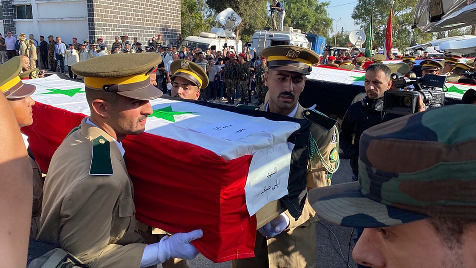 Syrian student officers carry the coffins of a victim who were killed on Thursday in a drone attack that hit a military graduation ceremony, during a mass funeral procession.