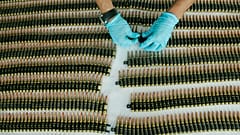 FILE - A police officer organises seized bullet cartridges as they are displayed to the press at the regional police headquarters in Cali, southern Colombia, 2010.