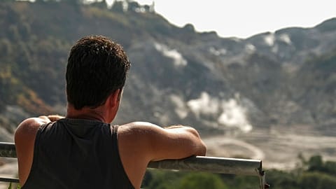 A tourist looks at the crater of the solfatara, one of the forty volcanoes that make up the Phlegraean Fields.