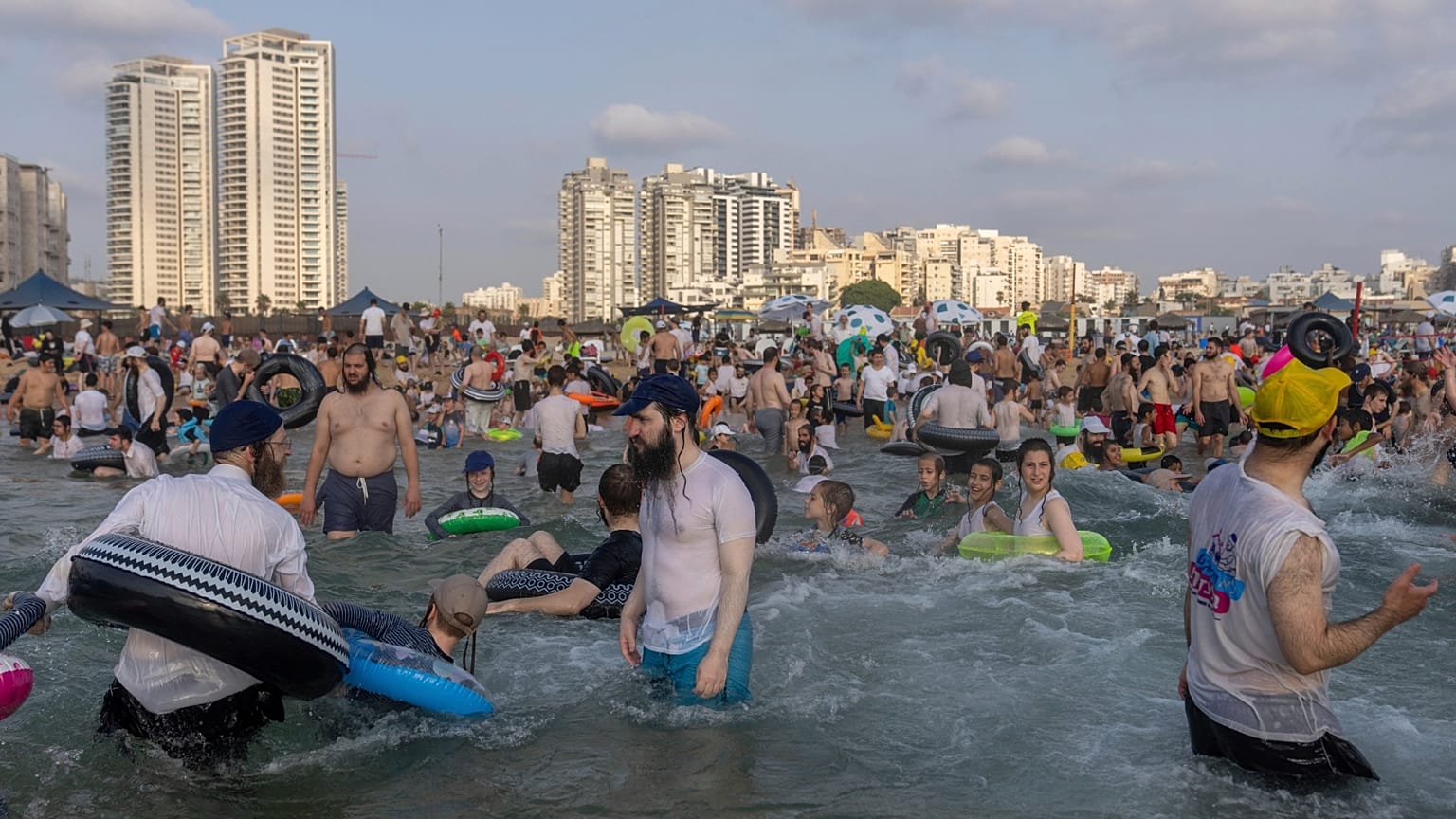 يقضي الرجال والأطفال اليهود المتدينون يومهم على شاطئ منفصل في أشدود، إسرائيل، الأربعاء، 16 أغسطس، 2023. الشاطئ منفصل بحيث يكون الرجال والنساء فقط في الأيام المتناوبة.