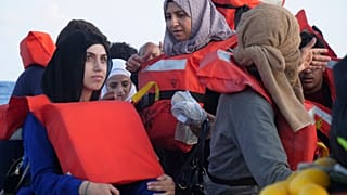 Migrants wear life vests as they are rescued by a MSF (Medecins Sans Frontiers) rescue team boat, after leaving Libya trying to reach European soil, on October 6.