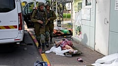 Soldados israelíes pasan junto a víctimas de los ataques de Hamás en Sderot