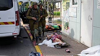 Soldados israelíes pasan junto a víctimas de los ataques de Hamás en Sderot