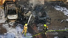 Israelische Feuerwehrleute löschen ein Feuer, nachdem eine aus dem Gazastreifen abgefeuerte Rakete auf einem Parkplatz in Aschkelon, Südisrael, eingeschlagen ist.
