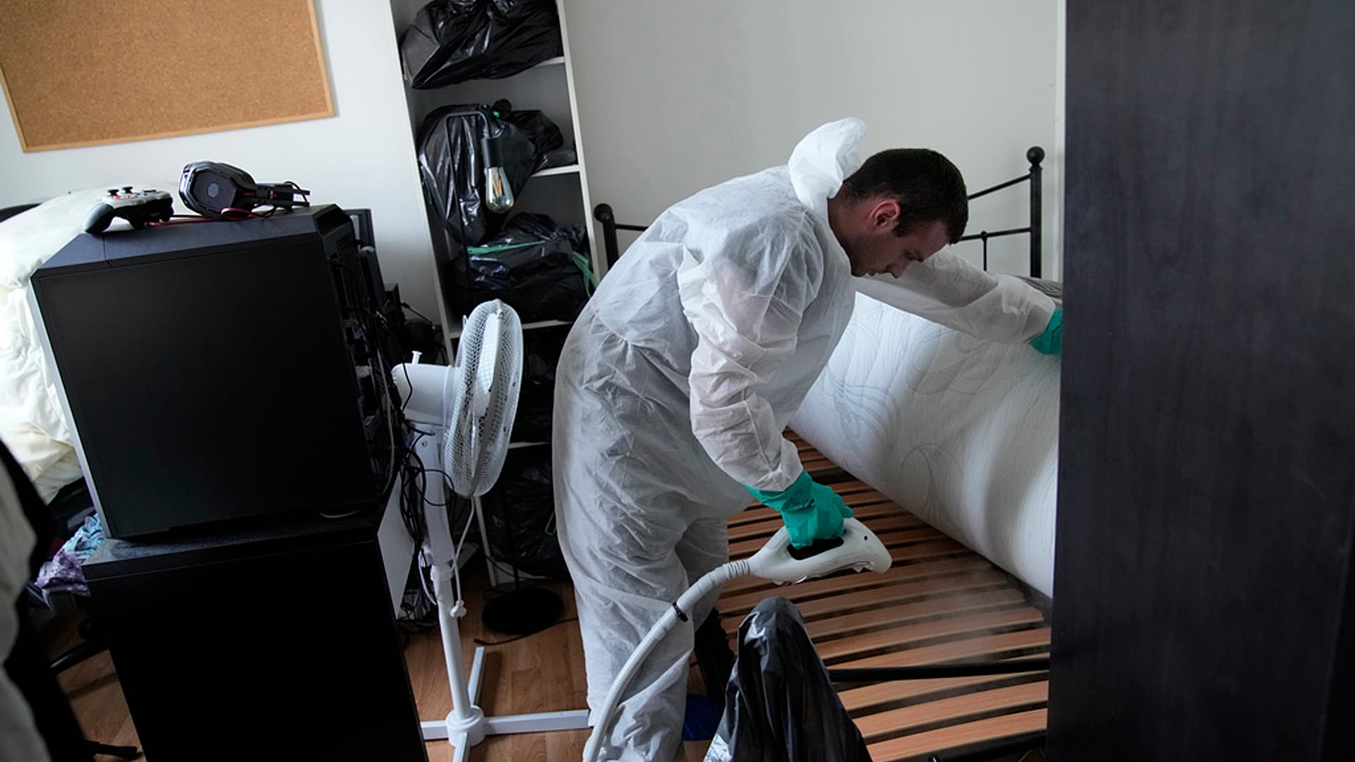 O técnico de controlo de pragas Lucas Pradalier pulveriza vapor numa cama de um apartamento em Paris. 