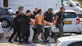 Les forces de sécurité israéliennes évacuent une femme blessée d'un site touché par une roquette tirée depuis la bande de Gaza, à Ashkelon, dans le sud d'Israël, 7/10/2023
