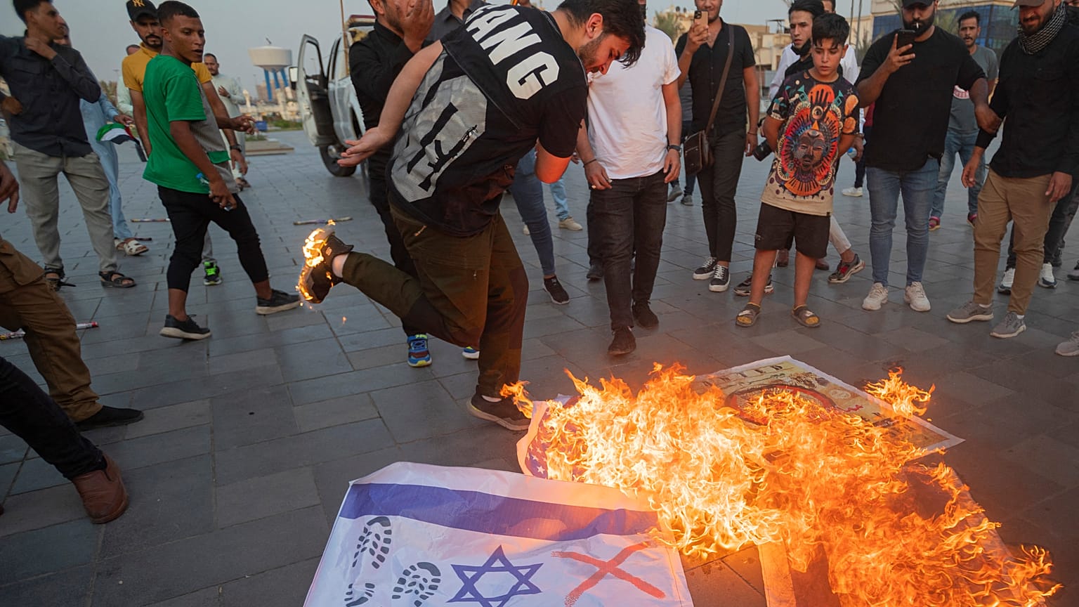 Des Irakiens brûlent des drapeaux israéliens lors d'un rassemblement organisé dans le centre de Bagdad en soutien aux Palestiniens, samedi.