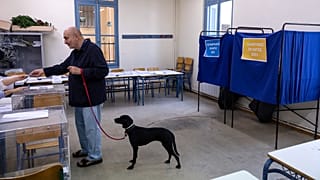 A man votes at a voting station during regional and municipal elections, in Athens