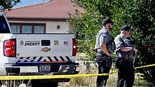 Fremont County deputies guard the road leading to the Return to Nature Funeral Home in Penrose, Colo. Thursday, Oct. 5, 2023.