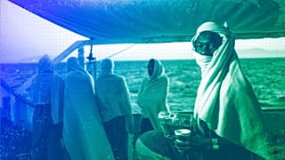 migrants stand on the deck of the Open Arms boat, after being rescued off the coast of Libya, August 2018