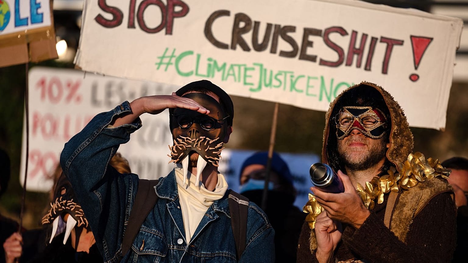 Members of the anti-cruise collective (anti-croisieres) wearing masks take part in the demonstration in the port du Rosmeur in Douarnenez.