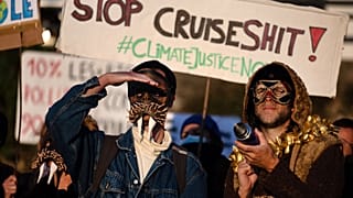 Members of the anti-cruise collective (anti-croisieres) wearing masks take part in the demonstration in the port du Rosmeur in Douarnenez.