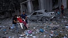 Palestinianos caminham nas ruínas de Gaza, após ataques aéreos israelitas