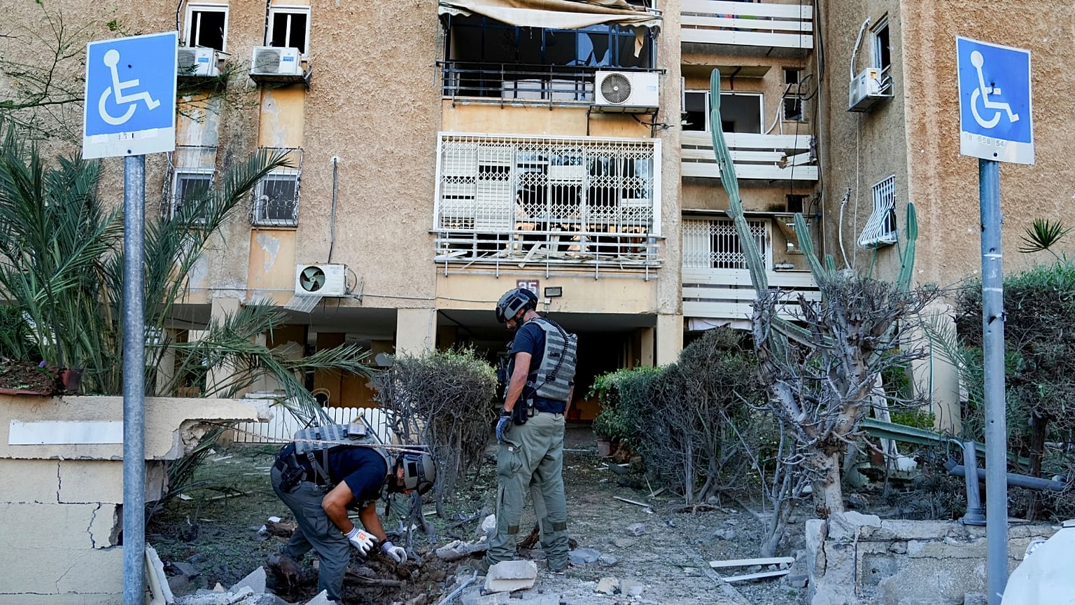 Members of Israeli bomb squad unit inspect a site hit by a rocket fired from the Gaza Strip, in Ashkelon, Israel, Tuesday, Oct. 10, 2023. 