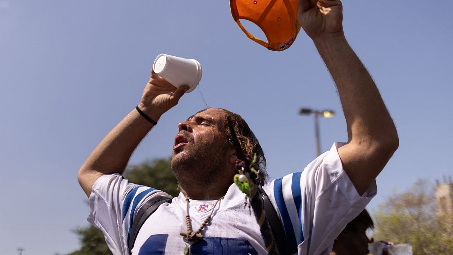 A man pours water atop his head outside the Emergency Aid Coalition during a heat wave in Houston, Texas, US, August 2023. 