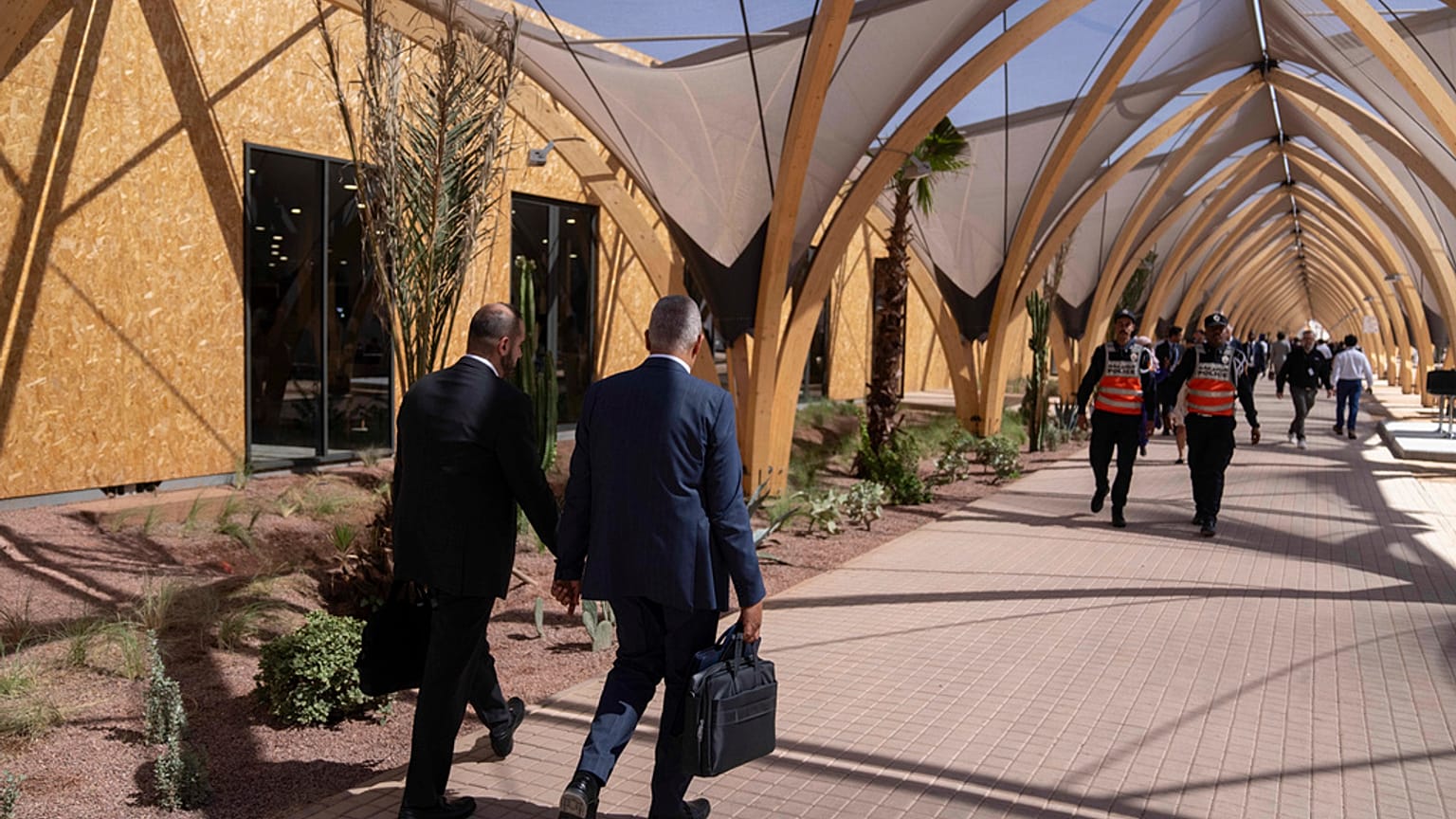Participants walk inside a convention center hosting the IMF and World Bank annual meetings, in Marrakech, Morocco