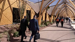 Participants walk inside a convention center hosting the IMF and World Bank annual meetings, in Marrakech, Morocco