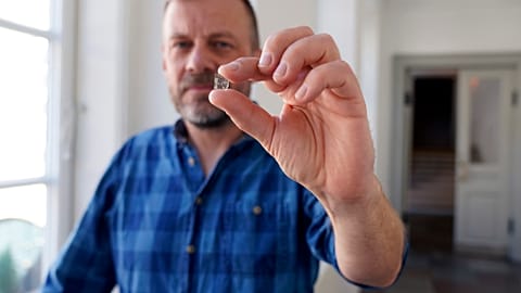 Senior Researcher at the National Museum of Denmark Mads Dengsø Jessen holds a window glass fragment from the Viking Age.