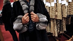 Eine Frau probiert einen Pelzmantel an, am 25\. Oktober 2008 im Hotel Drouot in Paris, zwei Tage vor der Versteigerung der Modeartikel.