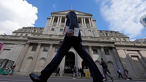 A man walks past the Bank of England, at the financial district in London, on May 11, 2023. 